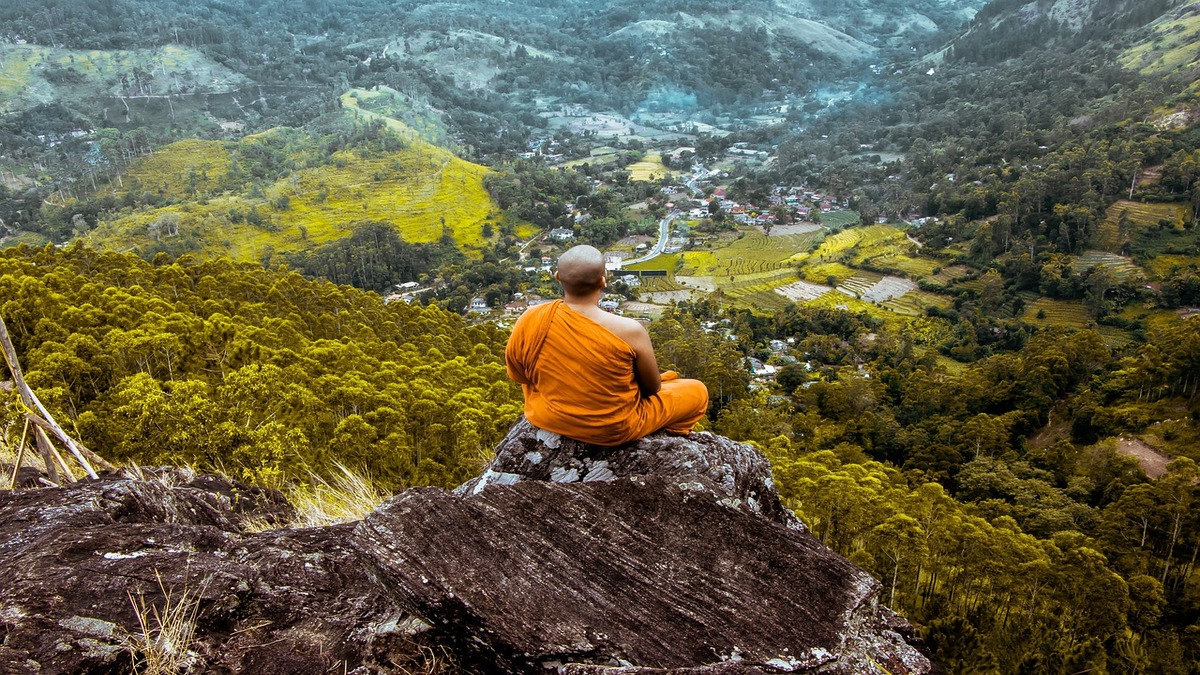 Budhist monk meditating in the hills